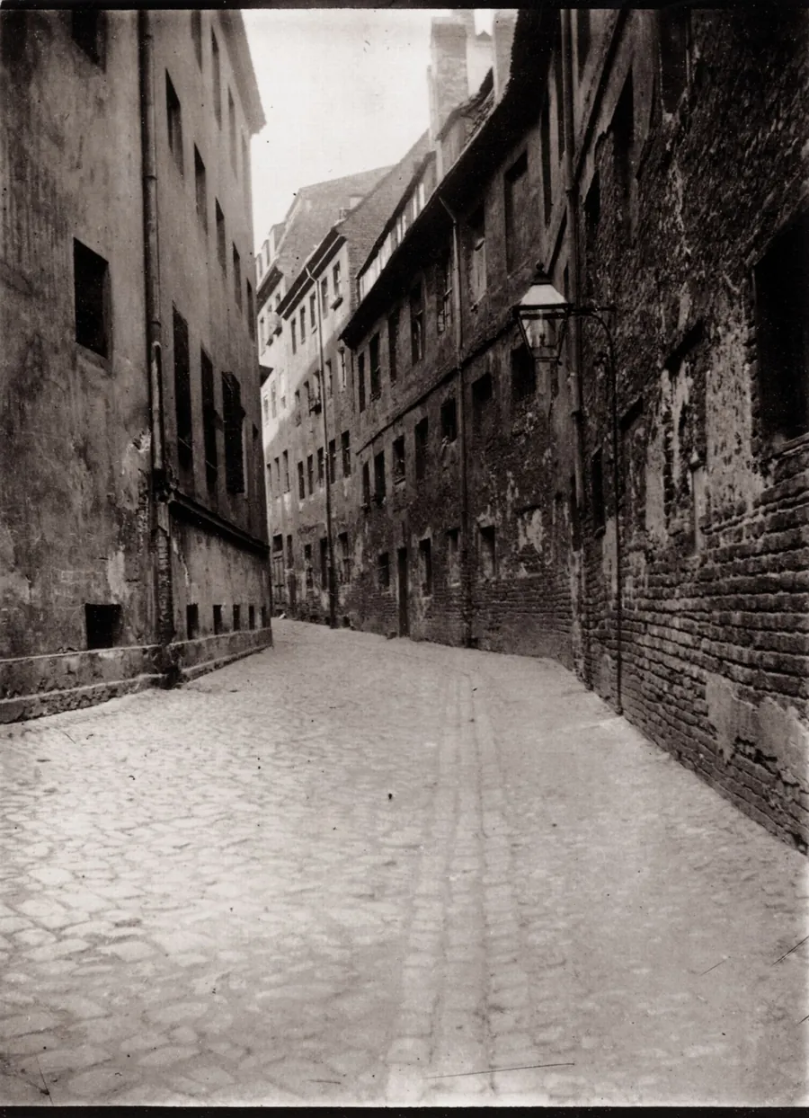 Enge Berliner Gasse zwischen Mietshäusern mit Kopfsteinpflaster um 1900