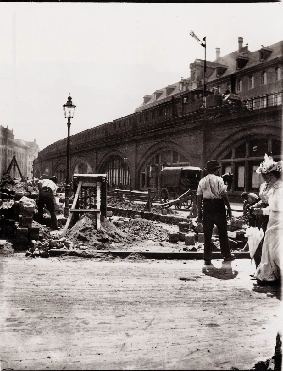 Arbeiter brechen in Berlin um 1900 das Pflaster auf, daneben liegt der Aushub