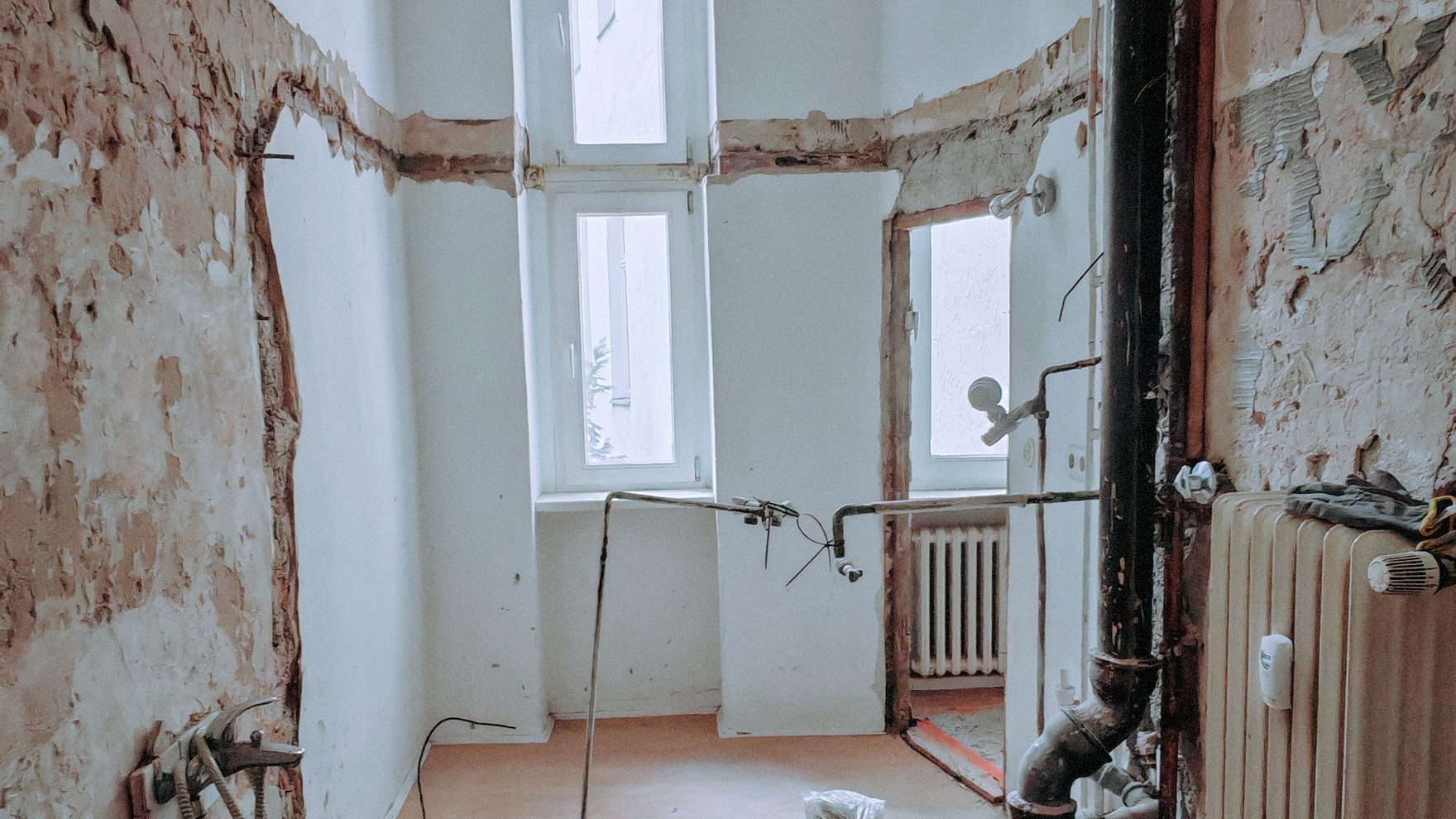 Bad auf Rohbau zurückgebaut, Putz ab – der Heizkörper hängt unversehrt an der Wand