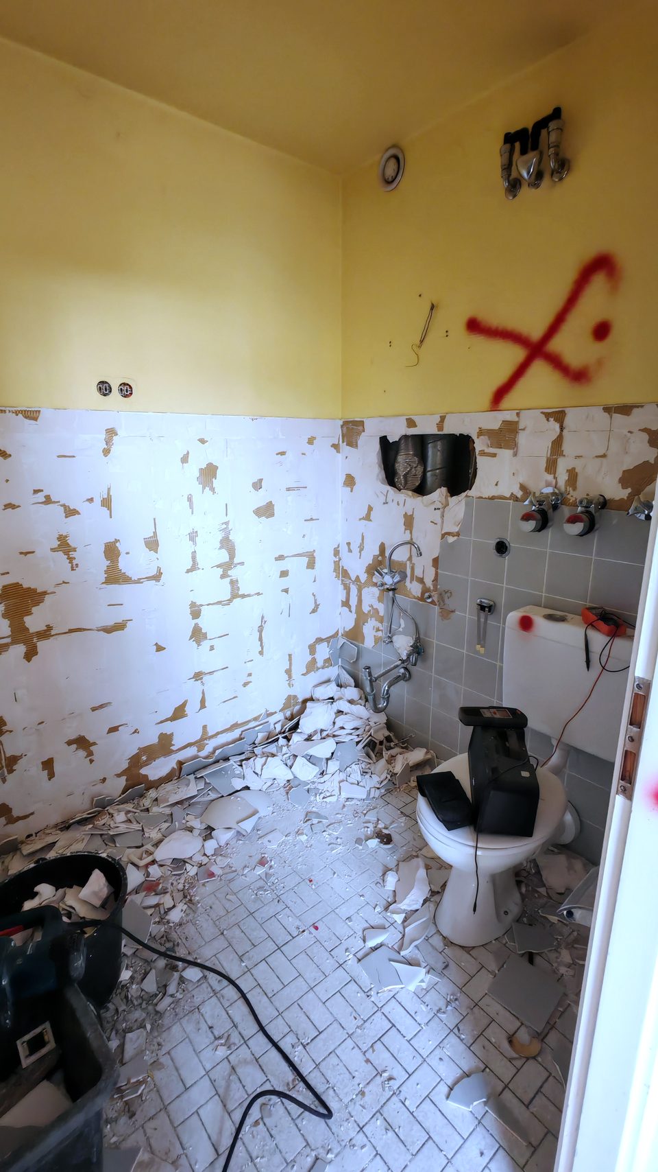 Badezimmerwand mit roten Markierungen, die anzeigen, was entfernt wird