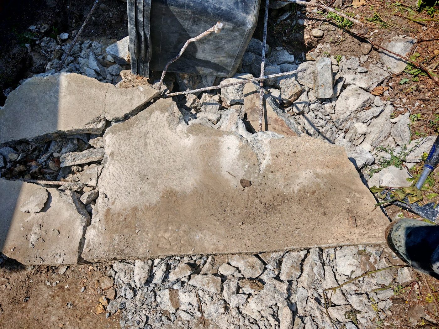 Aufgestemmte Betonplatte, große Bruchstücke liegen auf dem Schutt