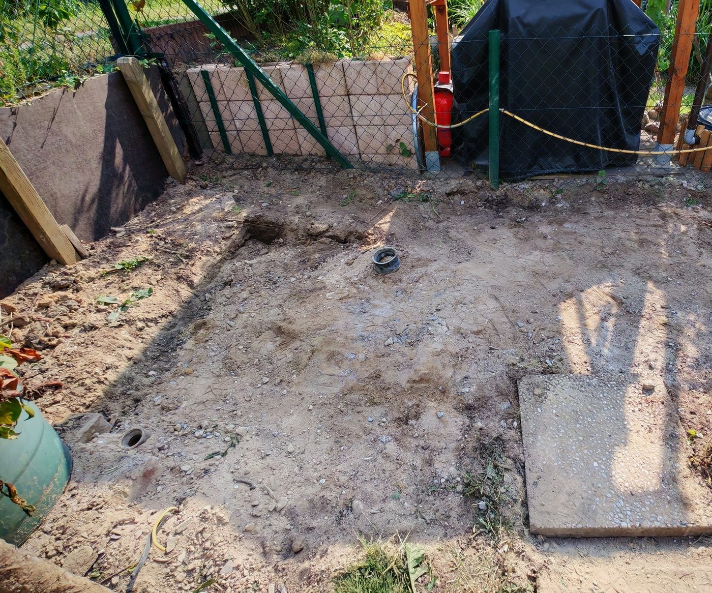 Freie Erdfläche im Kleingarten, wo vorher die Betonplatte lag