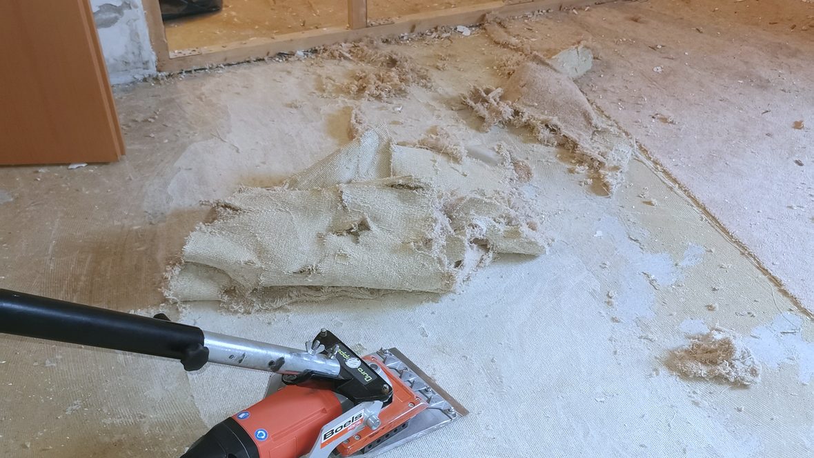 Bodenschleifmaschine trägt Kleberreste vom Estrich ab
