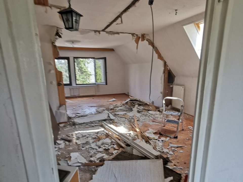 Dachgeschoss während des Rückbaus, Gipskarton abgenommen, Schutt am Boden