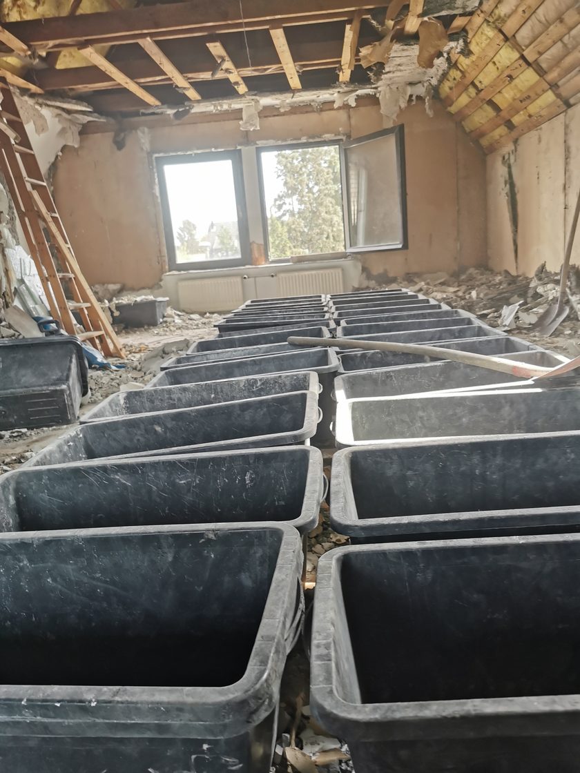 Dachraum voller gefüllter Mörtelwannen mit sortiertem Bauschutt