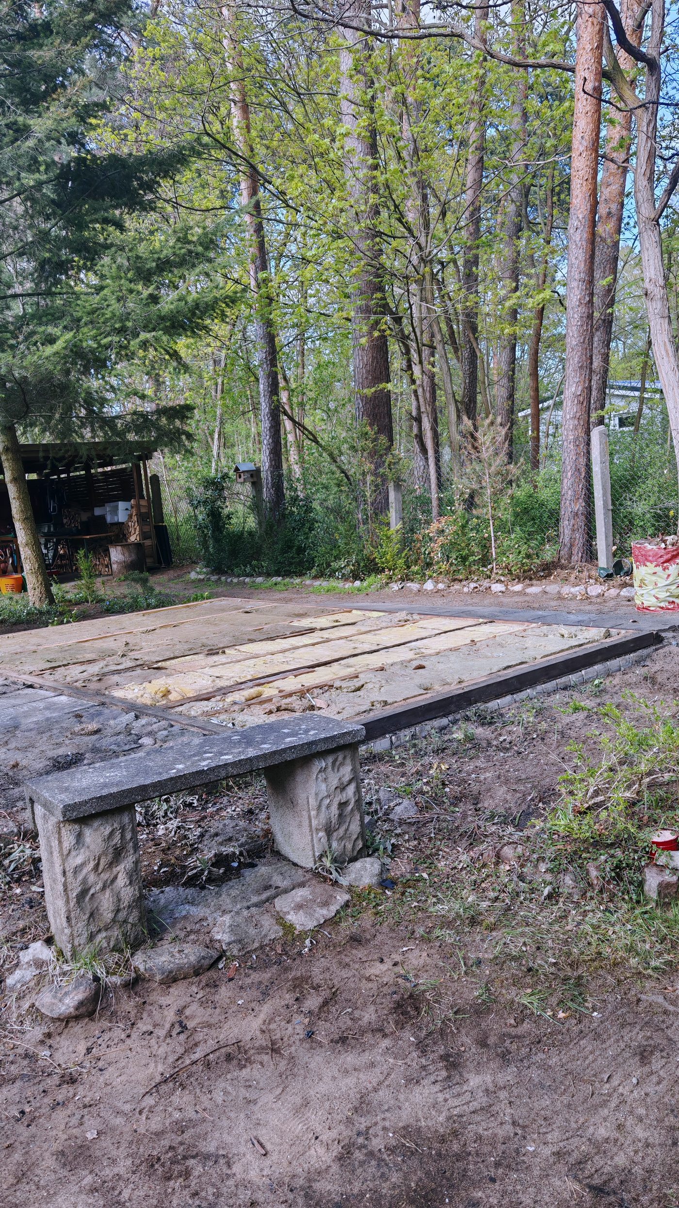 Geräumte Fläche nach dem Rückbau, Bodenplatte sichtbar, Wald ringsum