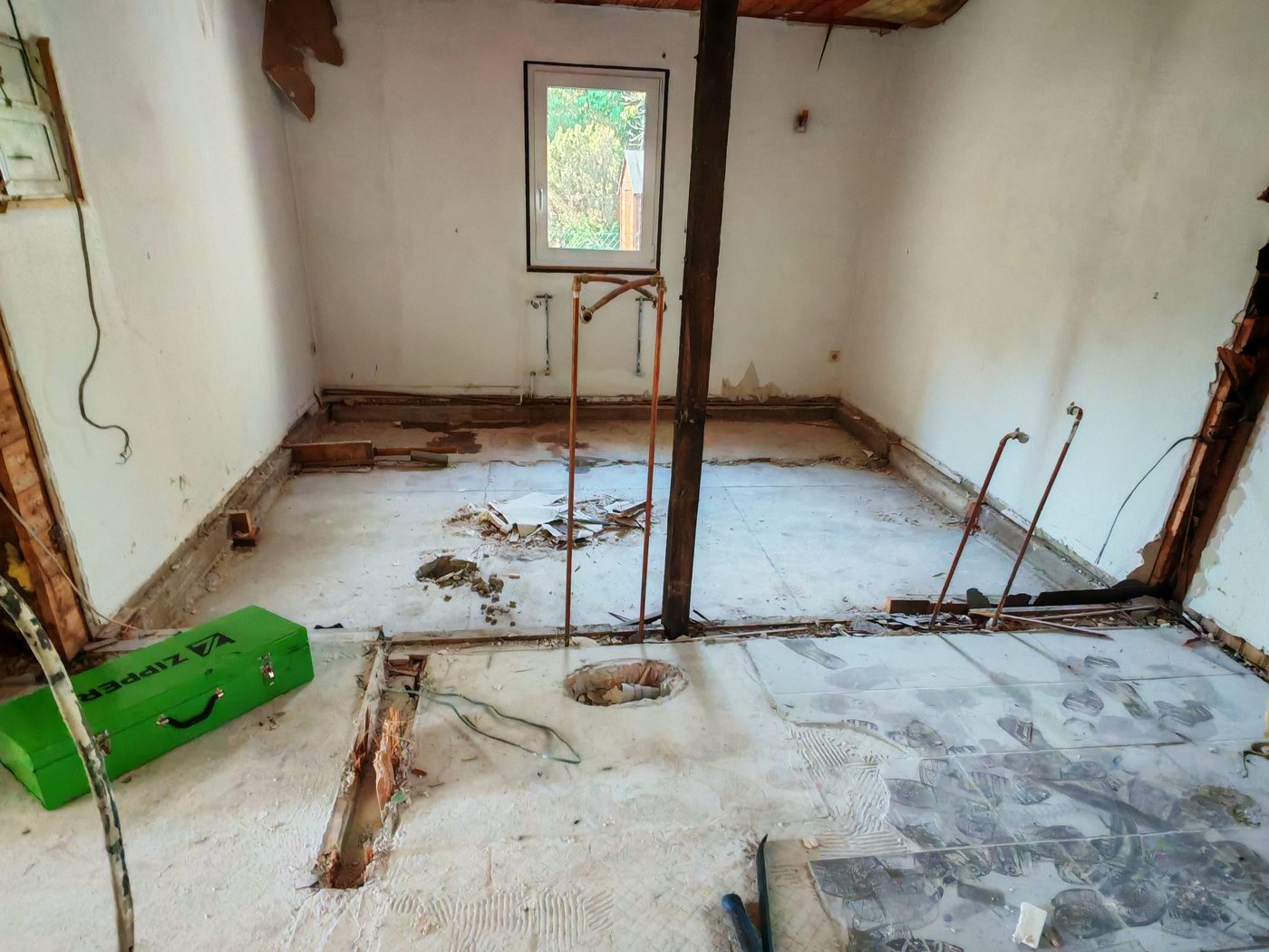 Fliesenboden wird mit der Brechstange vom Kleberbett gelöst