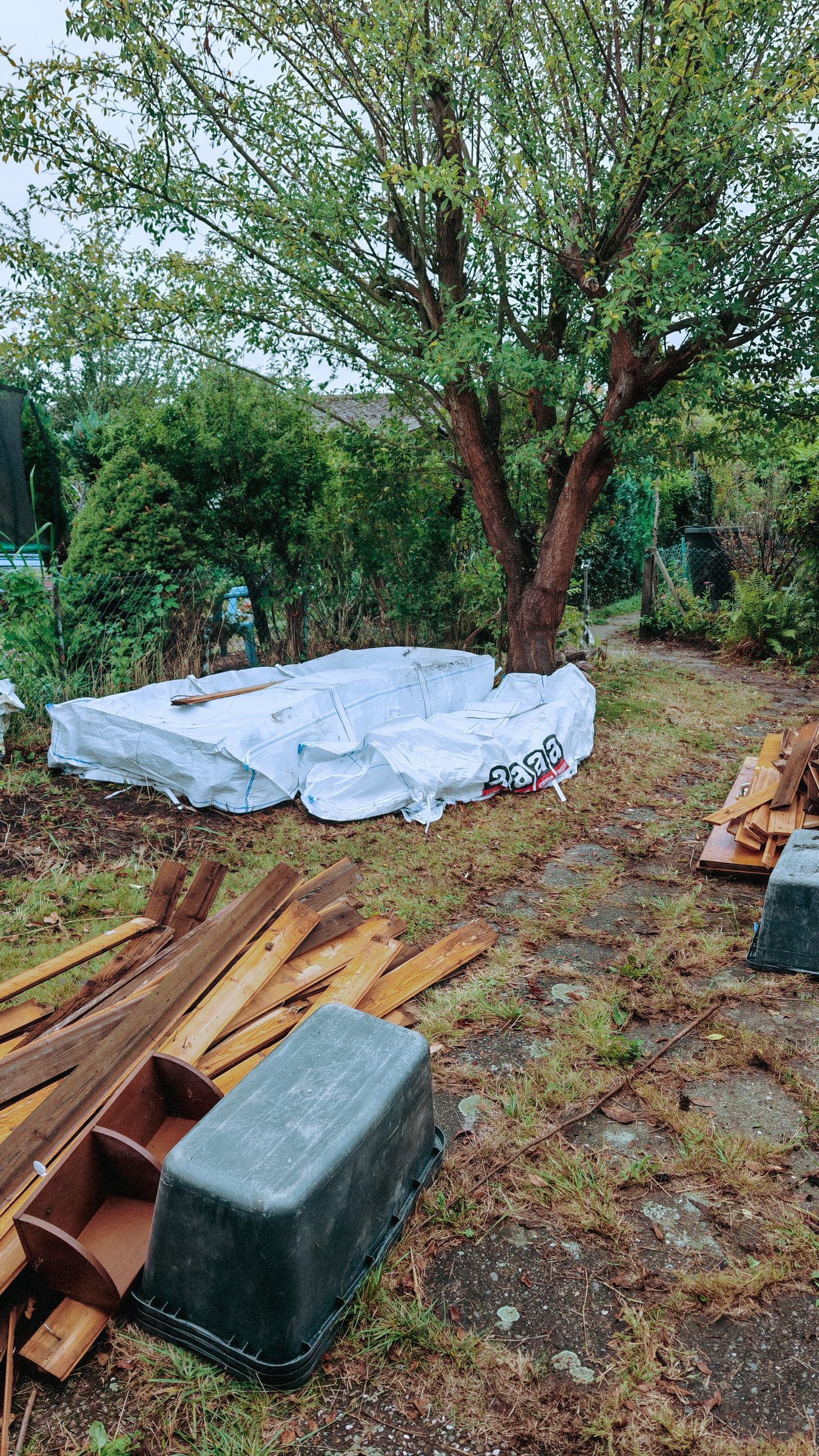 Gestapeltes Holz und gefüllte Big Bags auf der Parzelle am Morgen des zweiten Tages