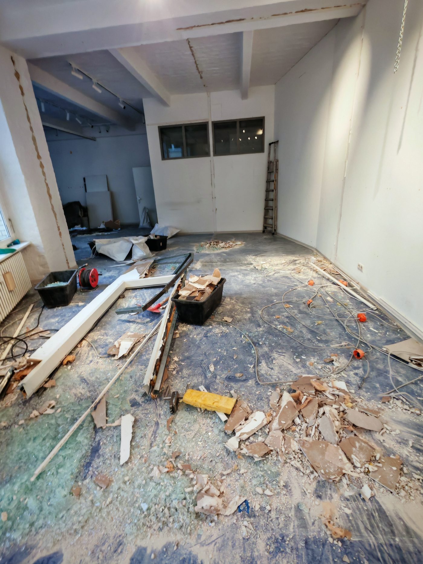 Gewerbefläche im Rückbau: Trennwand entfernt, Schutt und Glas auf dem Boden