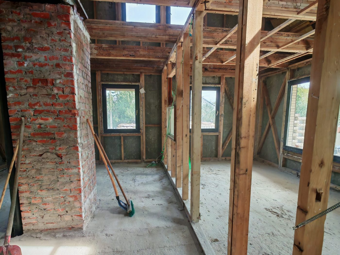 Entkerntes Reihenhaus von innen, Holzständerwerk und gemauerter Schornstein stehen frei
