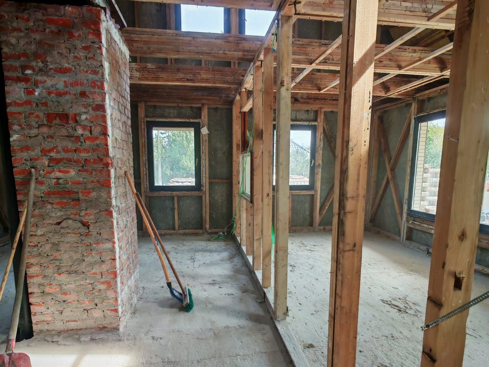 Entkerntes Haus mit freiem Ständerwerk, gefegtem Boden und Ziegelschornstein