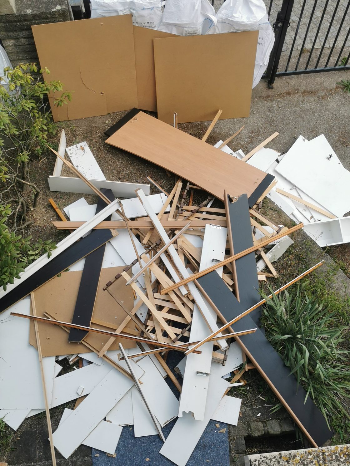 Sortierter Holzschutt neben Big Bags mit Dämmstoff