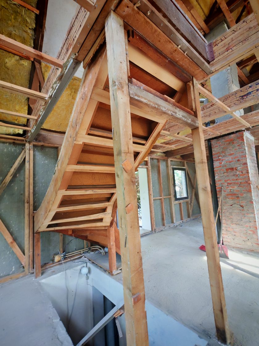 Freigelegte Holztreppe im entkernten Haus, Konstruktion und Ständerwerk sichtbar