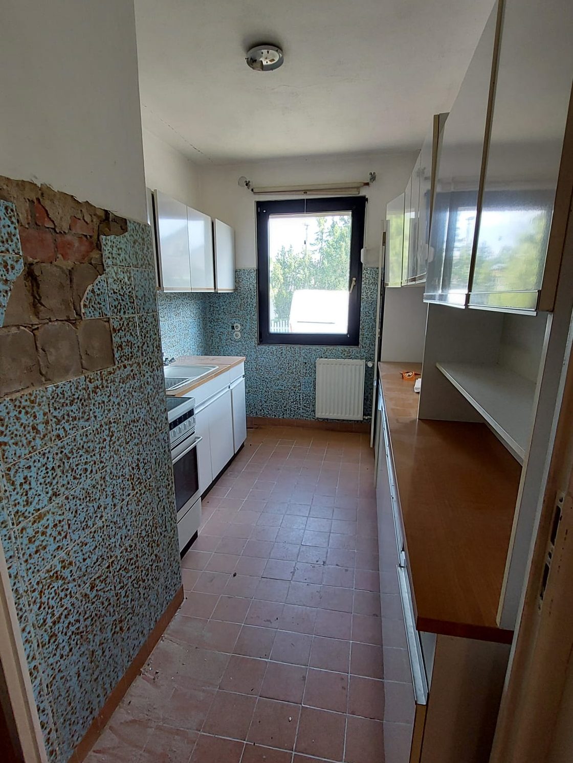 Alte Einbauküche mit Fliesenboden vor dem Rückbau