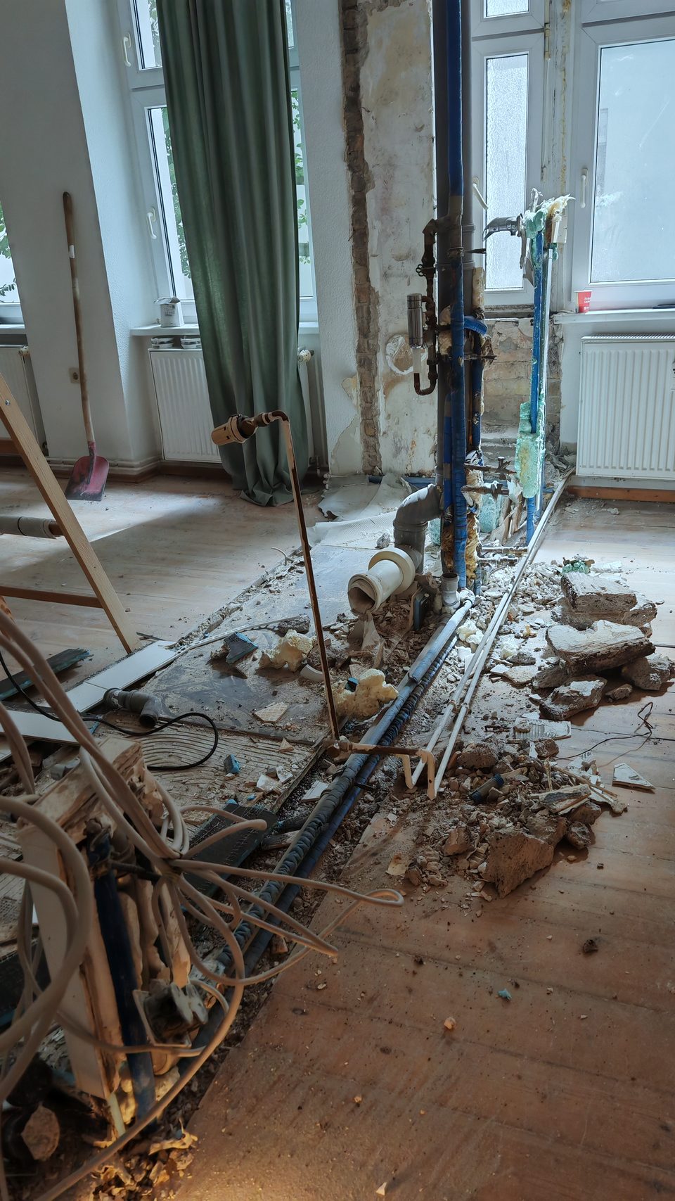 Freigelegte Leitungen, Heizkörper hängt unversehrt an der Wand
