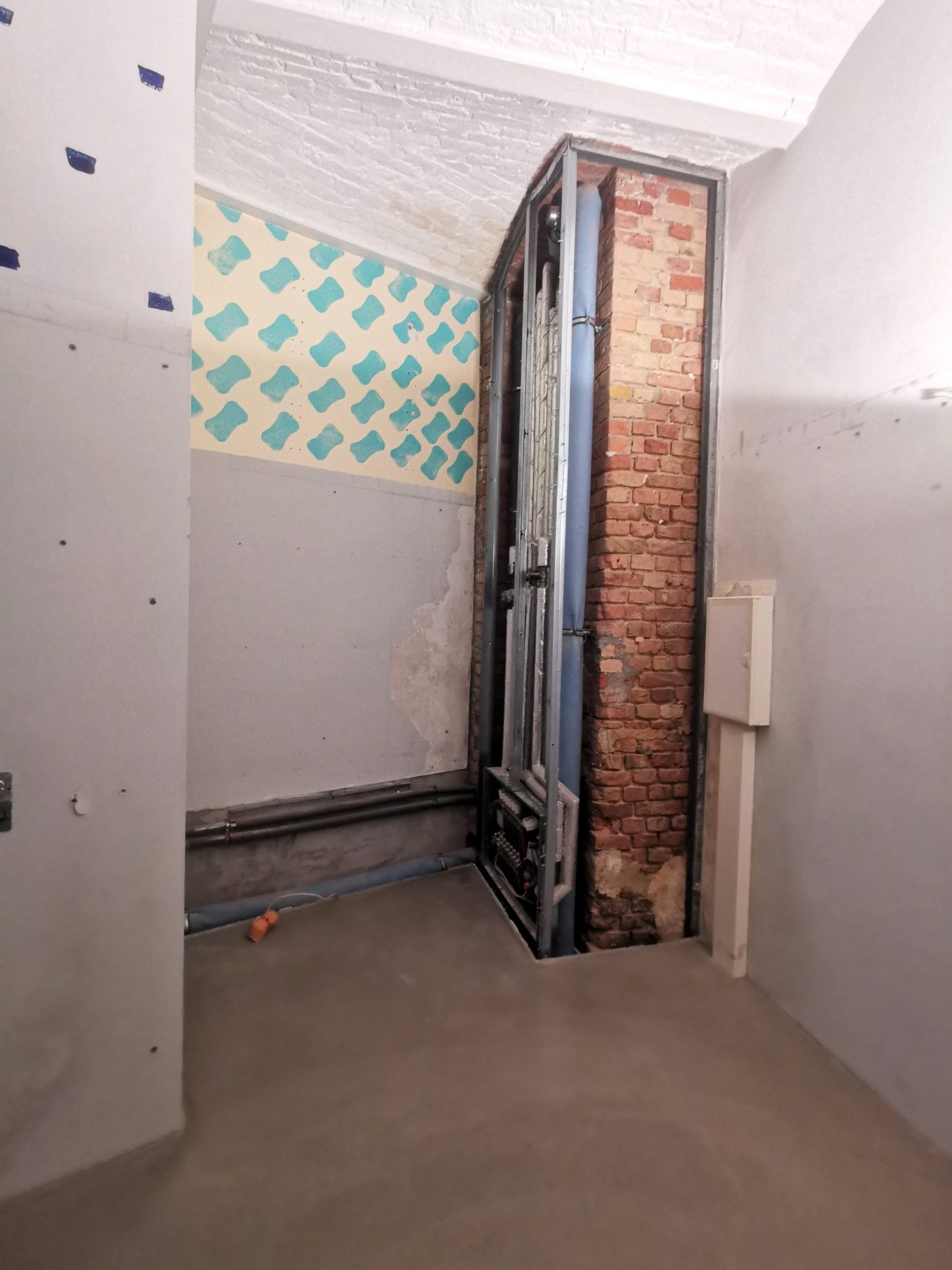 Derselbe Raum saniert: Installationsschacht offen, neuer Trockenbau steht
