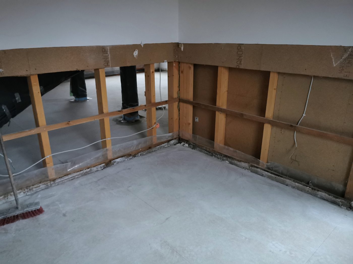 Trockenbauwand halb zurückgebaut, Holzständerwerk und Holzfaserplatten sichtbar