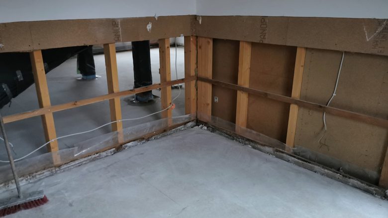 Trockenbauwand halb zurückgebaut, Holzständerwerk und Holzfaserplatten sichtbar